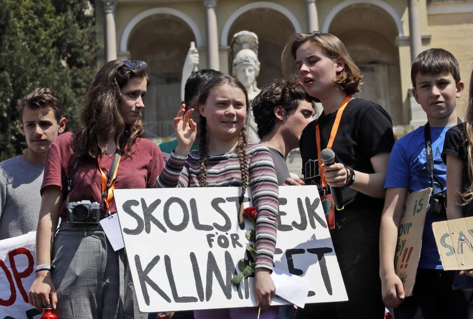 Swedish teenager and environmental activist Greta Thunberg waves as she holds a sign with writing reading in Swedish "School strike for the climate" during a Fridays for Future rally demanding more action be taken to save the environment, in Rome, Friday, April 19, 2019. Thunberg was in Rome to headline Friday's "school strike," the growing worldwide youth movement she spearheaded, demanding faster action against climate change.(AP Photo/Alessandra Tarantino)