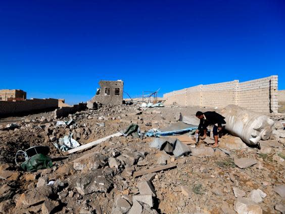 A man checks the debris of a building destroyed in Saudi-led air strikes in Yemen’s capital (AFP/Getty)