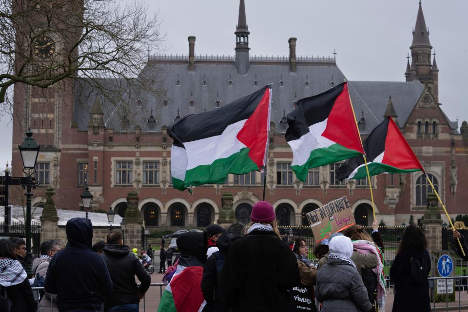 Pro-Palestinians demonstrators wave flags as they protest outside the United Nations' highest court during historic hearings, in The Hague, Netherlands, on Monday.