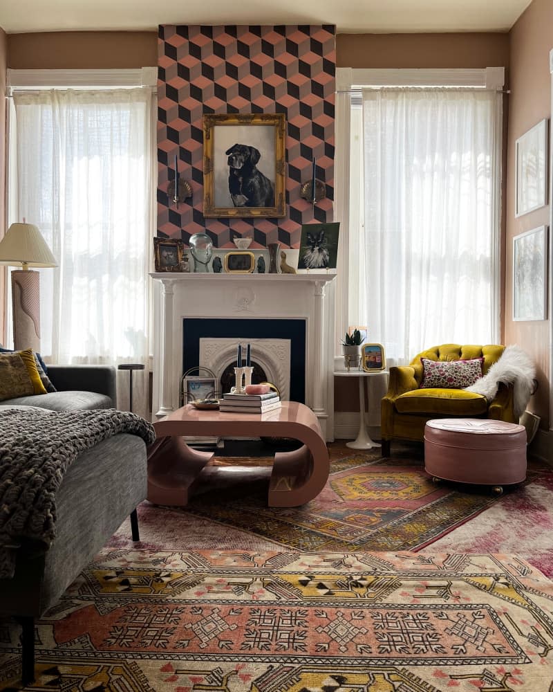 View of pink living room with multiple patterned area rugs.