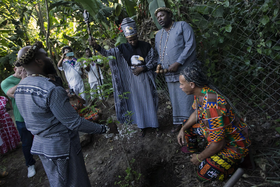 King Tchongolola Tchongonga Ekuikui VI, of Angola's Bailundo kingdom, center, holds up a staff during a Baobab tree planting ceremony during his visit to the "Quilombo do Camorim," a community of descendants of runaway slaves, many from Angola, in Rio de Janeiro, Brazil, Wednesday, Nov. 8, 2023. (AP Photo/Bruna Prado)