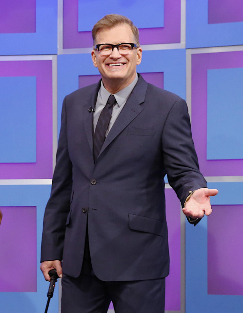 This 2013 photo released by CBS shows Drew Carey, host of "The Price is Right," on the set in Los Angeles. On Tuesday, April 7, the game show will air its 8,000th episode since it debuted on CBS in 1972. The concept hasn't changed through the years and it's a nonstop party in the hands of host Drew Carey. (AP Photo/CBS, Cliff Lipson)