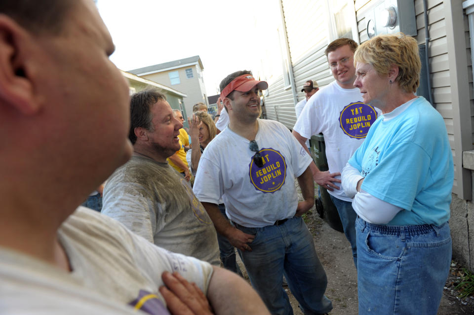 Rebuild Joplin volunteers, from left, Chuck Kralik, Phil Willcoxon, Christopher Spencer and Brian Ross, talk to St. Bernard Project volunteer Sharon Jenks, of Detroit, during a dedication of a newly renovated home that was destroyed by Hurricane Katrina in New Orleans, Thursday, March 1, 2012. (AP Photo/Cheryl Gerber)