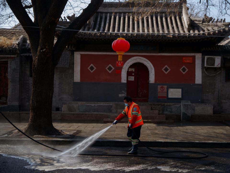 A worker sprays a street with disinfectant after the novel coronavirus outbreak in Beijing, China, February 23, 2020. .JPG