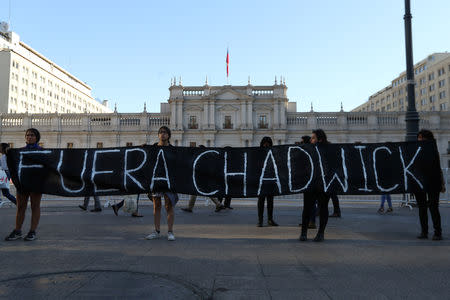 Indigenous Mapuche activists hold a banner, which reads: "Chadwick (Interior Minister) Out", outside the government house during a protest demanding justice for Camilo Catrillanca, an indigenous Mapuche man who was shot in the head during a police operation, in Santiago, December 20, 2018. REUTERS/Ivan Alvarado