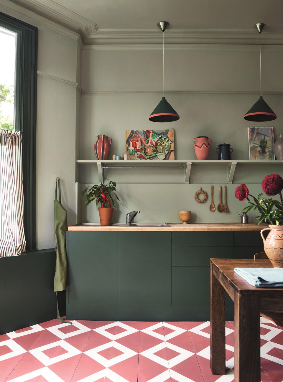 green kitchen with pink tile flooring and green cabinets