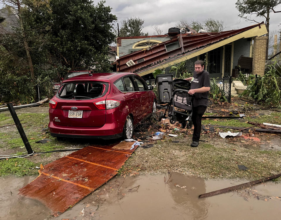 A house and car are seen damaged after a confirmed tornado on Friscoville Avenue in Arabi, La., in St. Bernard Parish, Wednesday, Dec. 14, 2022. (AP Photo/Matthew Hinton)