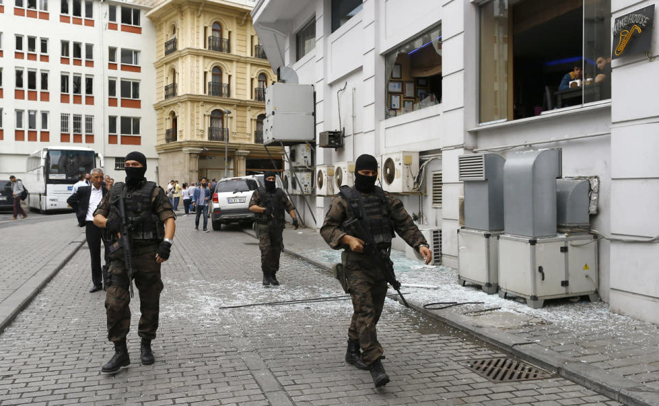 Special police walks near the site where a Turkish police bus was targeted in a bomb attack in a central Istanbul district