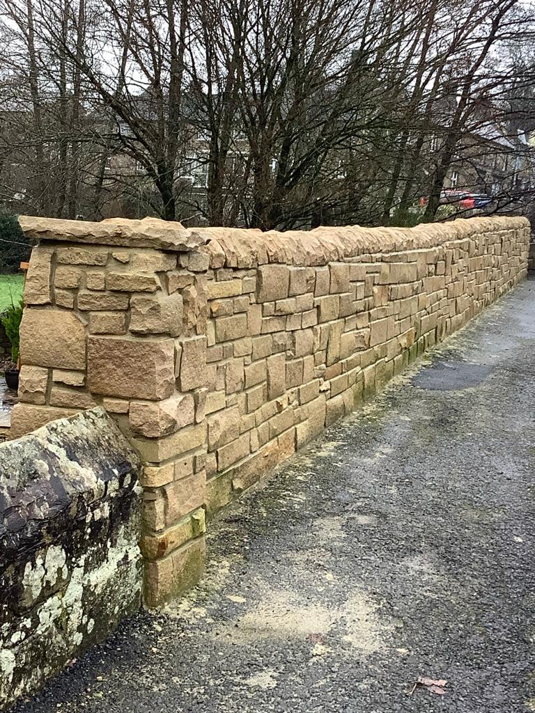 Bear Mason's stone wall seen from a public footpath which runs above his garden. He will now apply for retrospective planning permission. (SWNS)
