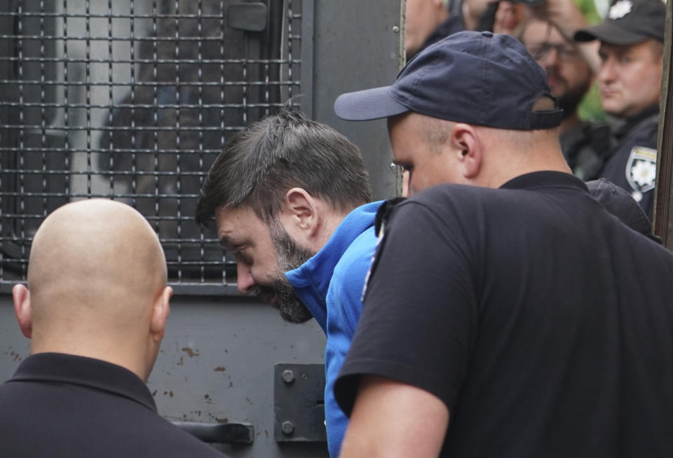 Kirill Vyshinskiy, the head of the Ukrainian office of Russia's RIA Novosti news agency in Ukraine, is escorted from a court room in Kiev, Ukraine, Monday, July 15, 2019. The Ukrainian Prosecutor General's office said that it is likely that a Russian journalist kept in detention in Ukraine is likely to be released. (AP Photo/Evgeniy Maloletka)