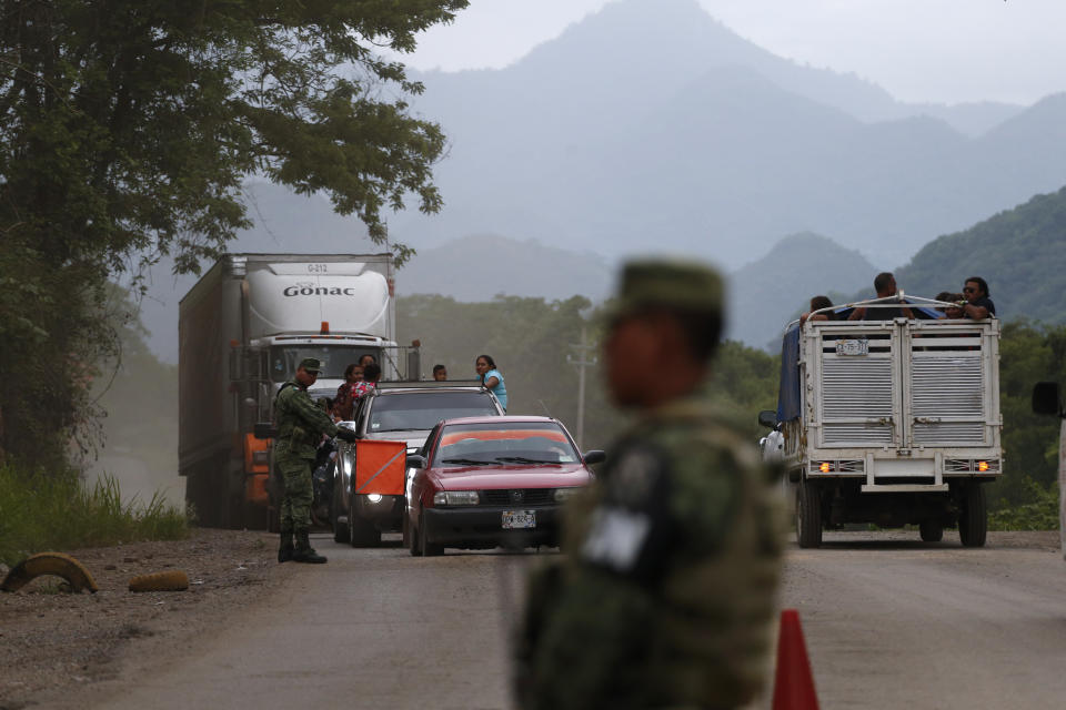 Soldiers wearing armbands for Mexico's National Guard man a temporary immigration checkpoint where officials were look for migrants, just north of Ciudad Cuauhtemoc, Chiapas State, Mexico, Saturday, June 15, 2019. Under pressure from the U.S. to slow the flow of migrants north, Mexico plans to deploy thousands of National Guard troops by Tuesday to its southern border region.(AP Photo/Rebecca Blackwell)