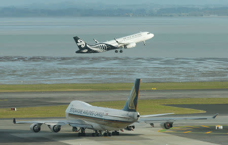 An Air New Zealand aircraft takes off from Auckland Airport alongside a Singapore Airlines cargo plane during fuel shortages in New Zealand, September 20, 2017. Picture taken September 20, 2017. REUTERS/Nigel Marple