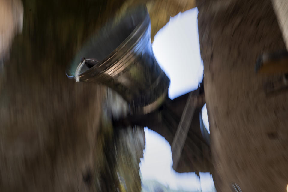 Roser Reixach, a student of the Vall d'en Bas School of Bell Ringers, performs playing a bronze bell at the church bell tower of the12th-century Sant Romà church, at the tiny village of Joanetes, about two hours north of Barcelona, Spain, Saturday, July 29, 2024. A school set up to revive the manual ringing of church bells has graduated its first class of 18 students after learning their ringing skills. (AP Photo/Emilio Morenatti)