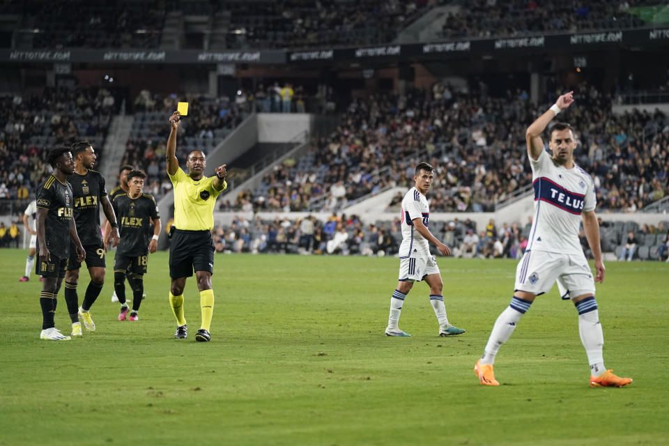 Vancouver Whitecaps defender Luís Martins, right, reacts as he is issued a yellow card during the second half of an MLS soccer match against Los Angeles FC in Los Angeles, Saturday, June 24, 2023. (AP Photo/Ashley Landis)