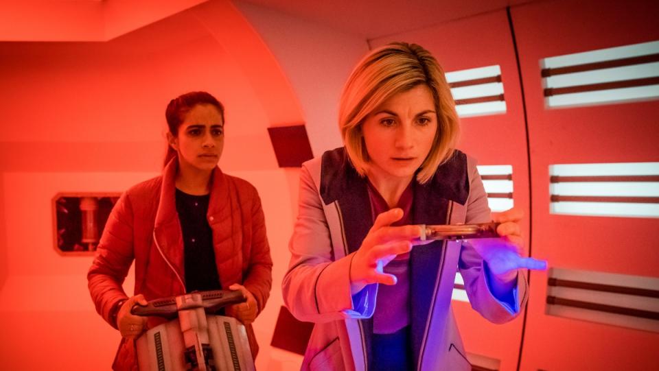 Doctor Who Yaz and Thirteen stand in hallway with red light