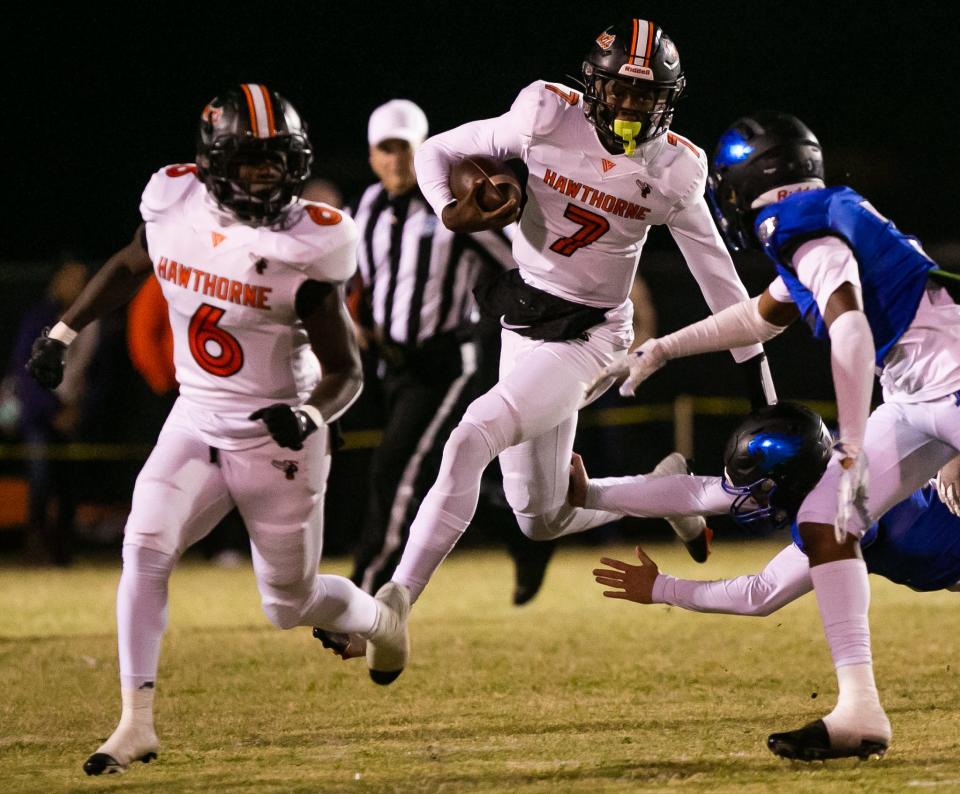 Hawthorne Hornets quarterback Cj Ingram (7) leap to avoid tackles in the first half. Hawthorne Hornets took on the Wildwood Wildcats in 1R Regional Semifinal at Hawthorne High School in Hawthorne, FL on Friday, November 18, 2022. Hawthorne won 33-15.  [Doug Engle/Ocala Star Banner]