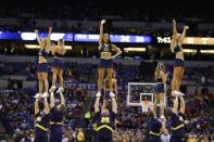 Michigan cheerleaders perform during the first half of an NCAA Midwest Regional semifinal college basketball tournament game against the Tennessee Friday, March 28, 2014, in Indianapolis. (AP Photo/Michael Conroy)