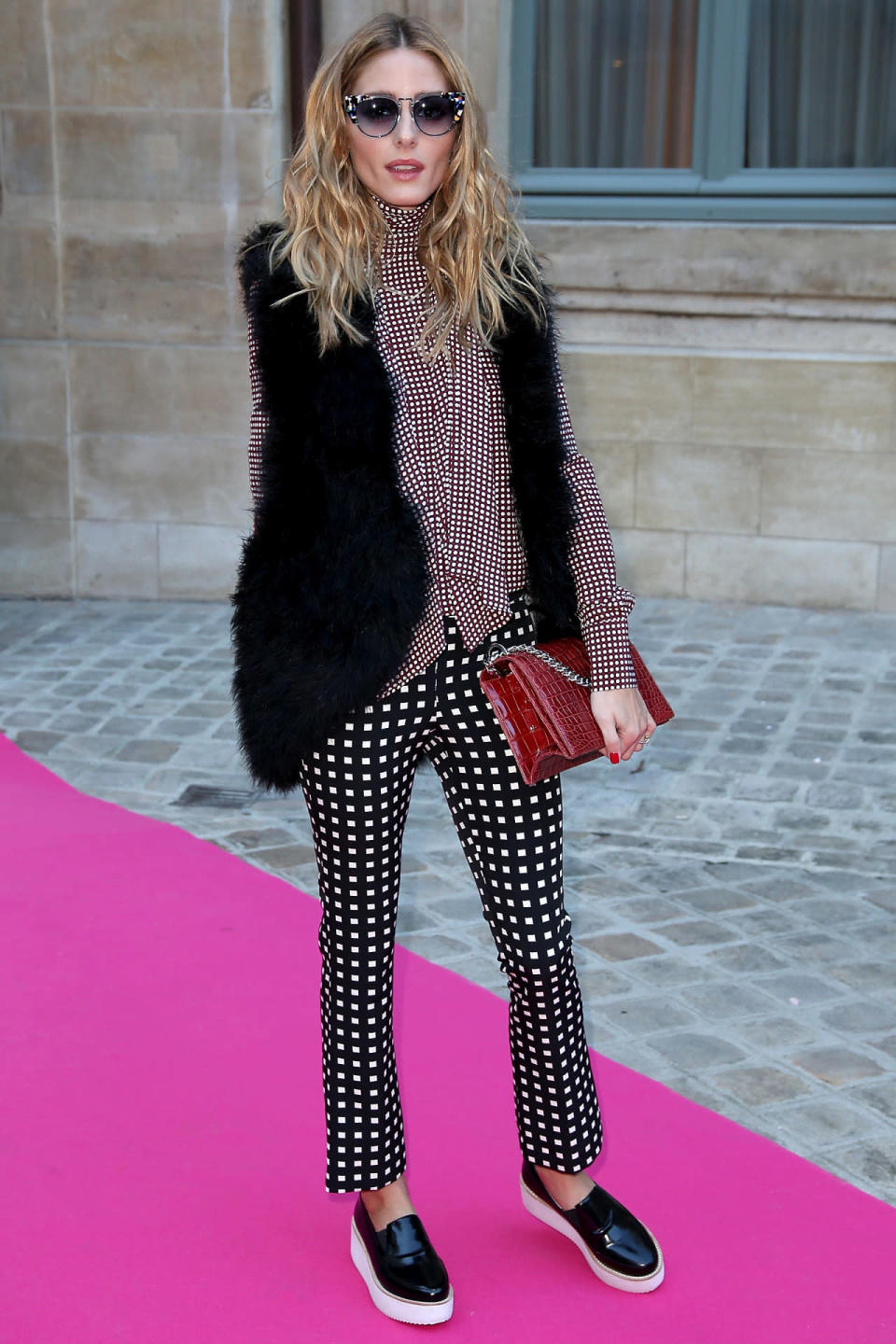 <p><b><b>Olivia Palermo in a printed outfit and fur vest at the Schiaparelli <b>spring/summer 2016 haute couture show</b> in Paris.</b></b></p><p>Palermo paired her prints oh-so-right in black and white polka dot pants and a high-neck printed top. She completed her look with embellished sunglasses, a fur vest, a red snakeskin bag, and patent leather platform sneakers. (<i>Getty Images</i>) </p>