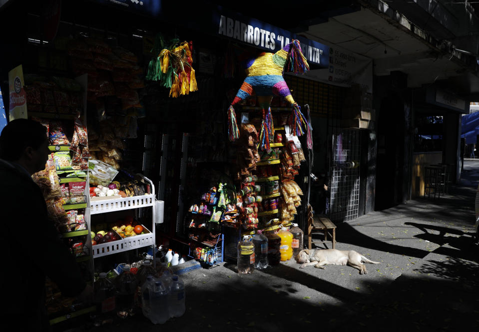 Un perro acostado frente a una tienda con piñatas en la colonia Roma Sur de la Ciudad de México el miércoles 19 de diciembre de 2018. Las noticias sobre las 10 nominaciones de “Roma” de Alfonso Cuarón a los Premios de la Academia hicieron que los residentes del barrio de la infancia del director recordaran con alegría sus propias memorias y anticiparan que mostrarán la película a sus hijos algún día. (Foto AP/Rebecca Blackwell)