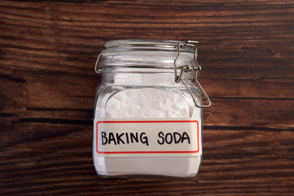 Glass preserving jar of baking soda on a wooden background