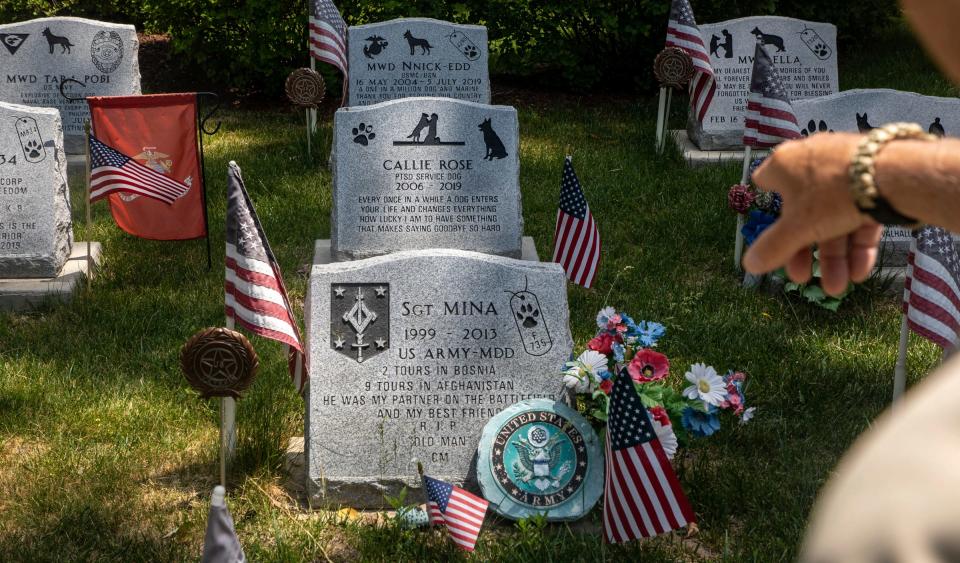 Phil Weitlauf, 81, director of Michigan War Dog Memorial, Inc., points at a gravestone, like the one for Mina, in inside the Michigan War Dog Memorial in South Lyon on June 14, 2023.