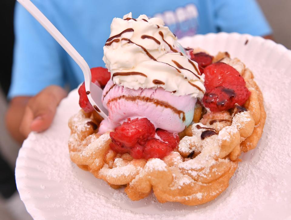 Aspen Street Treats is a food truck serving customers at the Duncan Event Center in Duncan, Saturday, April 16, 2022. It is one of several local food trucks that will be available at the upcoming Spring Fling events in Spartanburg. Aspen Smith holds a special funnel cake at the Aspen Street Treats truck.