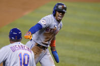 New York Mets' Francisco Lindor runs past third base to score on a throwing error by Miami Marlins center fielder Magneuris Sierra during the first inning of a baseball game, Friday, May 21, 2021, in Miami. (AP Photo/Lynne Sladky)