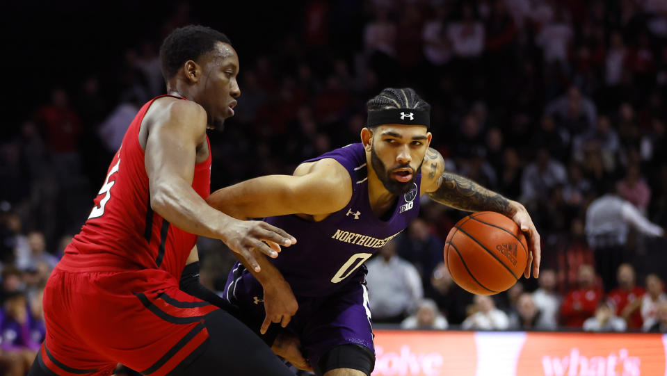 Northwestern guard Boo Buie (0) drives to the basket against Rutgers forward Aundre Hyatt during the first half of an NCAA college basketball game, Sunday, Mar.5, 2023 in Piscataway, N.J. (AP Photo/Noah K. Murray)