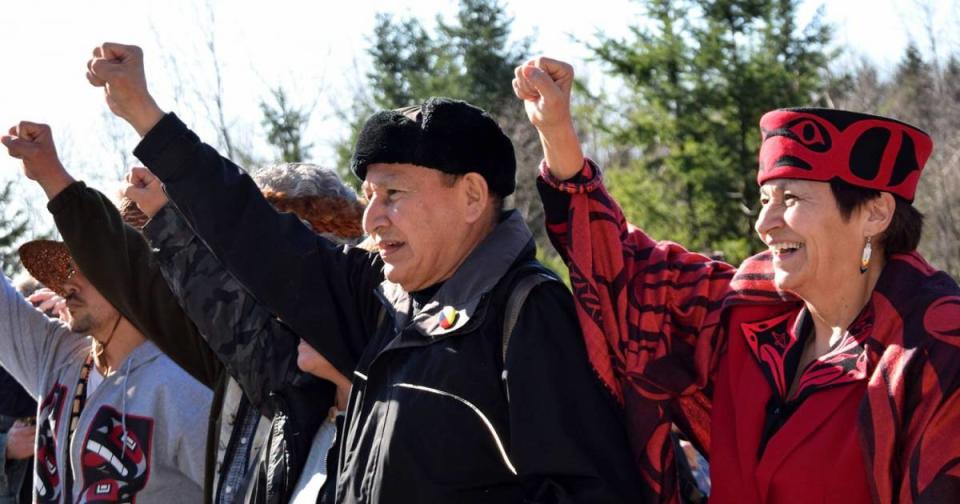 Stewart and Joan Phillip stand with their fists in the air against Kinder Morgan on Burnaby Mountain.