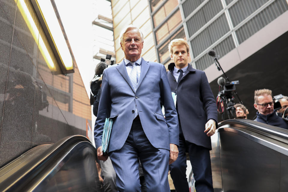 European Union chief Brexit negotiator Michel Barnier, left, rides an escalator on his way to a meeting at the Europa building in Brussels, Friday, Oct. 11, 2019. EU negotiator Michel Barnier says that he had a "constructive meeting" with British Brexit envoy Stephen Barclay and underscored the cautious optimism since Thursday's meeting between British Prime Minister Boris Johnson and his Irish counterpart Leo Varadkar. (AP Photo/Francisco Seco)