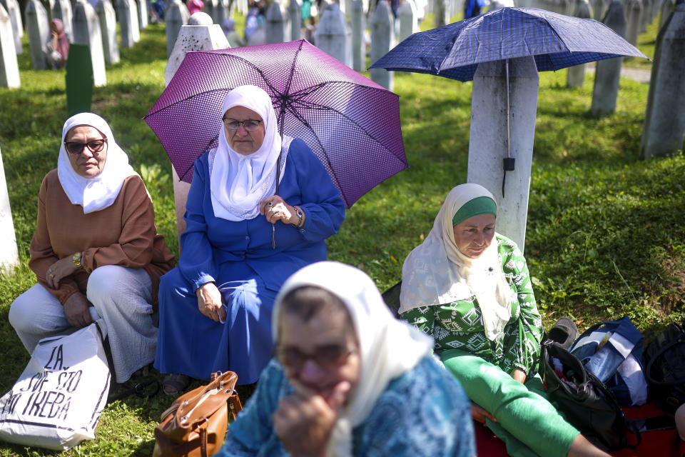 Bosnian muslim women wait for the mass burial ceremony for 14 newly identified victims, at the Srebrenica Memorial Centre, in Potocari, Bosnia, Thursday, July 11, 2024. Thousands gather in the eastern Bosnian town of Srebrenica to commemorate the 29th anniversary on Monday of Europe's only acknowledged genocide since World War II. (AP Photo/Armin Durgut)
