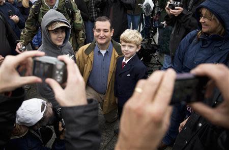 Senator Ted Cruz (R-TX) poses for pictures with children during the "Million Vet March on the Memorials" rally in front of the National U.S. World War II Memorial in Washington October 13, 2013. REUTERS/Joshua Roberts