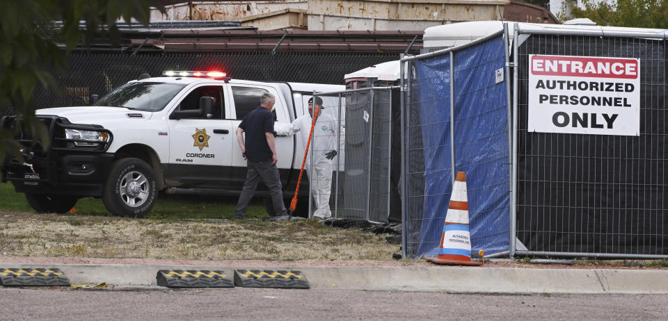 The remains of some of the 115 decomposing bodies discovered at the Return to Nature Funeral Home in Penrose, Colo., arrive at the El Paso County Coroner's Office in Colorado Springs, Colo., Tuesday, Oct. 10, 2023. Temporary structures and refrigerated trucks filled a parking lot next to the office where they will be beginning the massive task of trying to identify the remains. (Jerilee Bennett/The Gazette via AP)