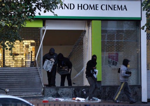 Youths steal electrical goods from a store in Birmingham on August 9, 2011. Up to 15,000 people are estimated to have taken part in the riots that flared across Britain last year, with most of those under 24 years old with poor academic records, a study has shown