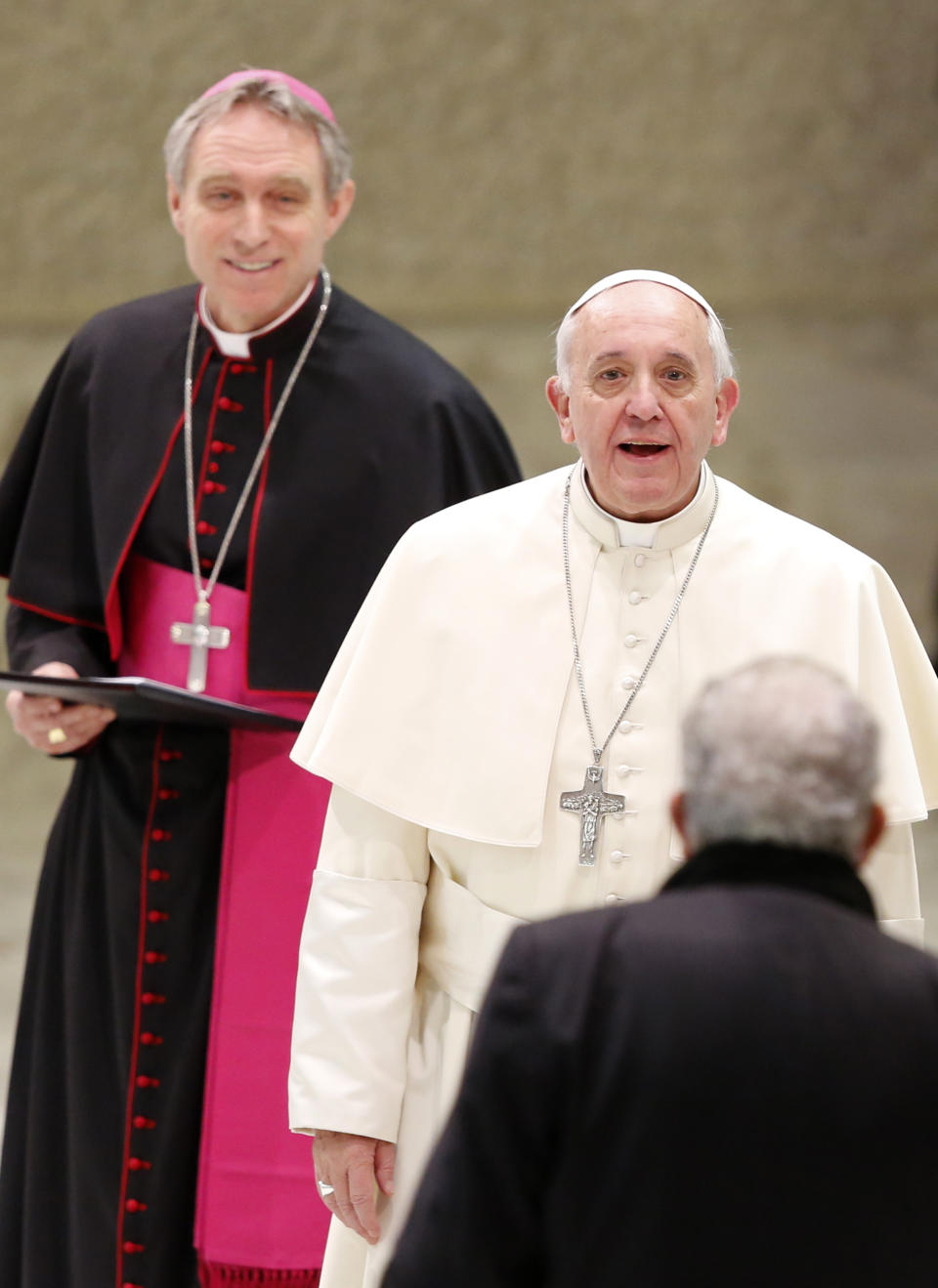 Pope Francis, flanked by Monsignor Georg Gaenswein, left, greets Kiko Arguello, a founder of the Neocatechumenal Way missionary movement, during an audience in the Paul VI hall, at the Vatican, Saturday, Feb. 1, 2014. Francis met with thousands members of the Neocatechumenal Way, a community founded in Spain in the 1960s that seeks to train Catholic adults in their faith and is known for sending large families as missionaries around the world. (AP Photo/Riccardo De Luca)