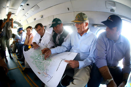 Peru's President Pedro Pablo Kuczynski next to prime minister Fernando Zavala (R) look at a map on a helicopter on the way to observe the floods in Piura, northern Peru, March 28, 2017. Luis Guillen/Presidential Palace/Handout via Reuters