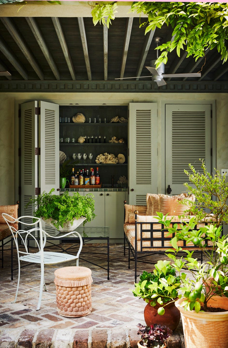 Poolside drinks are served at a glazed tile bar behind folding doors.