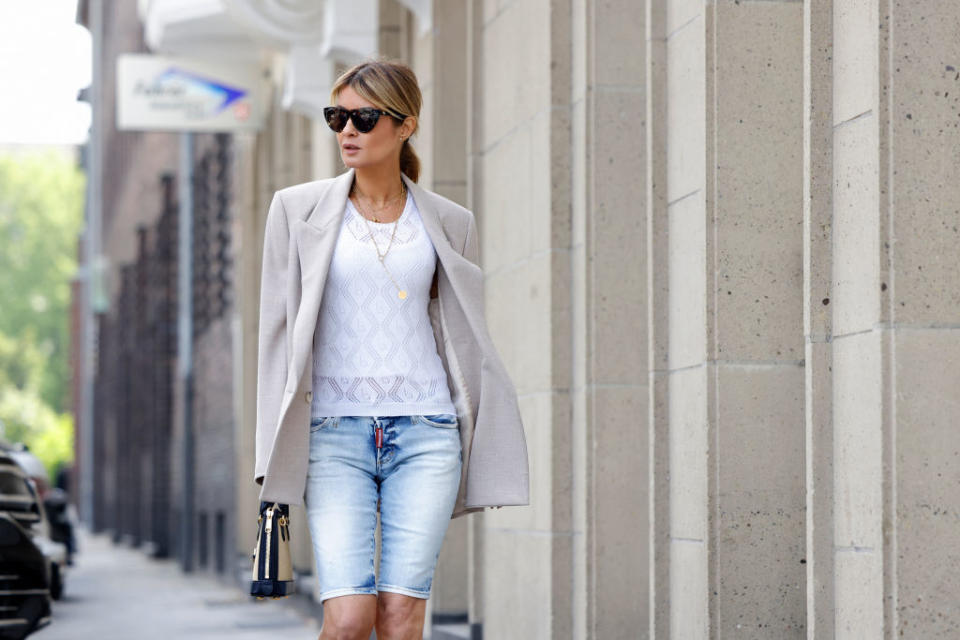 DUSSELDORF, GERMANY - JUNE 02: Influencer Gitta Banko wearing a beige oversized linen blazer by Zara, a white pullover with lace detail by Boscana, light blue denim jeans bermuda pants by Bottega Veneta and a black and beige bag with gold details by Gucci during a street style shooting on June 2, 2021 in Dusseldorf, Germany. (Photo by Streetstyleshooters/Getty Images)