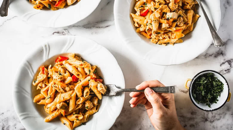 penne pasta bowls with fork