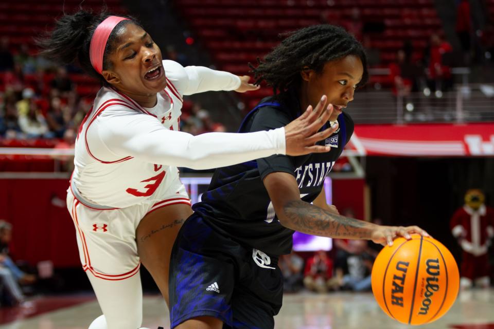 Weber State Wildcats guard Kaiija Lesane (15) dribbles the ball with Utah Utes guard Lani White (3) on defense during the women’s college basketball game between the University of Utah and Weber State University at the Jon M. Huntsman Center in Salt Lake City on Thursday, Dec. 21, 2023. | Megan Nielsen, Deseret News