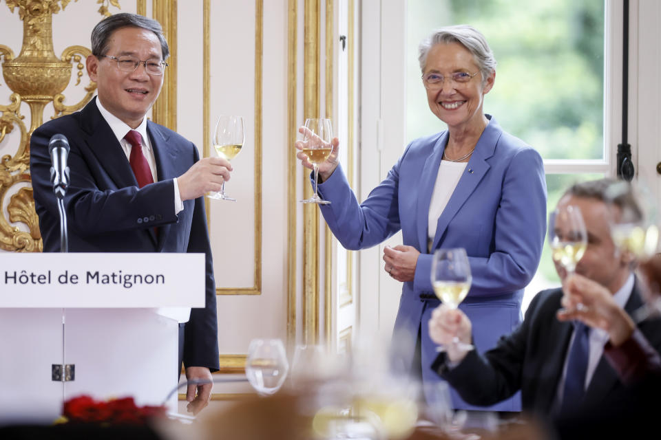 China's Prime Minister Li Qiang toasts with French Prime Minister Elisabeth Borne, right, during a working lunch Thursday, June 22, 2023 in Paris. World leaders, heads of international organizations and activists are gathering in Paris for a two-day summit aimed at seeking better responses to tackle poverty and climate change issues by reshaping the global financial system. (AP Photo/Thomas Padilla, Pool)