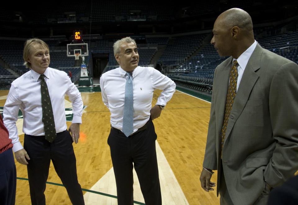 New York investment firm executives Marc Lasry , left, and Wesley Edens talks to Milwaukee Bucks assistant coach Jim Cleamons Wednesday, April 16, 2014, in Milwaukee. The Bucks announced that owner Herb Kohl has reached a deal to sell the franchise to Edens and Lasry. (AP Photo/Morry Gash)