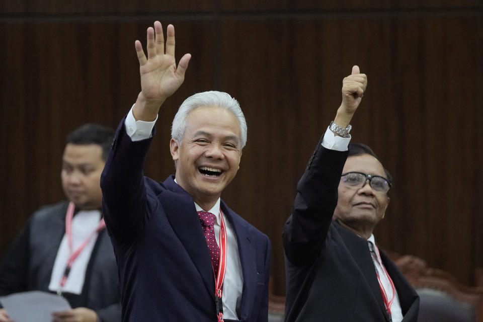 Presidential candidate Ganjar Pranowo, left, and his running mate Mahfud MD wave at the media upon arrival for their election appeal hearing at the Constitutional Court in Jakarta, Indonesia, Monday, April 22, 2024. The country's top court on Monday rejected appeals lodged by two losing presidential candidates who are demanding a revote, alleging widespread irregularities and fraud at the February polls. (AP Photo/Dita Alangkara)