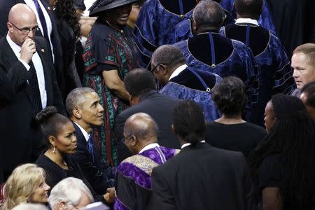 U.S. President Barack Obama greets attendees after delivering the eulogy honoring Clementa Pinckney, a pastor and state lawmaker killed in last week's church shooting in Charleston, during funeral services in Charleston, South Carolina June 26, 2015. REUTERS/Jonathan Ernst