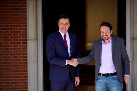 FILE PHOTO: Spain's acting Prime Minister Pedro Sanchez greets Unidas Podemos' (Together We Can) leader Pablo Iglesias at the Moncloa Palace in Madrid