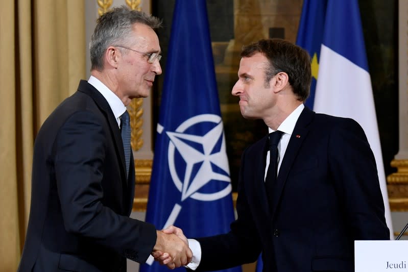 NATO Secretary General Jens Stoltenberg and French President Emmanuel Macron shake hands at the end of a news conference after their meeting at the Elysee palace in Paris