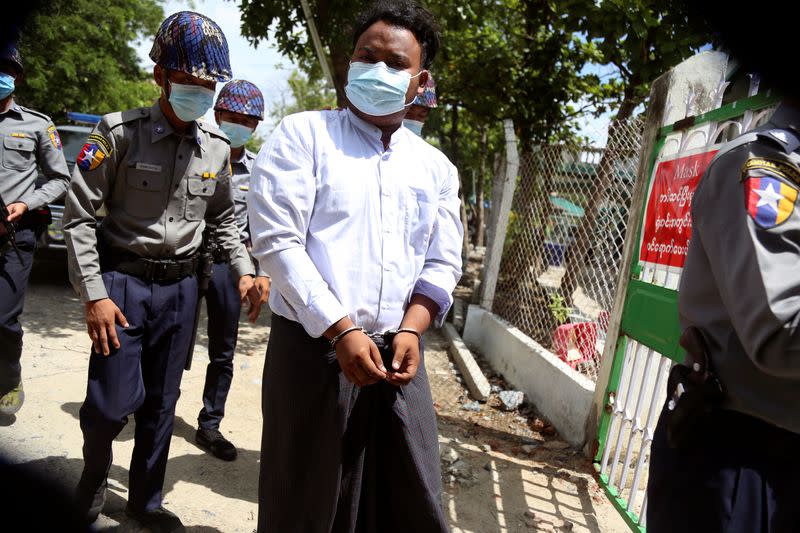 Member of the All Burma Federation of Students Union is escorted by police as he arrives at a court in Mandalay, Myanmar