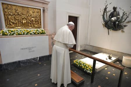 Pope Francis prays on the grave of one of the three little sheperd at the Shrine of Our Lady of Fatima in Portugal May 13, 2017. Osservatore Romano/Handout via REUTERS