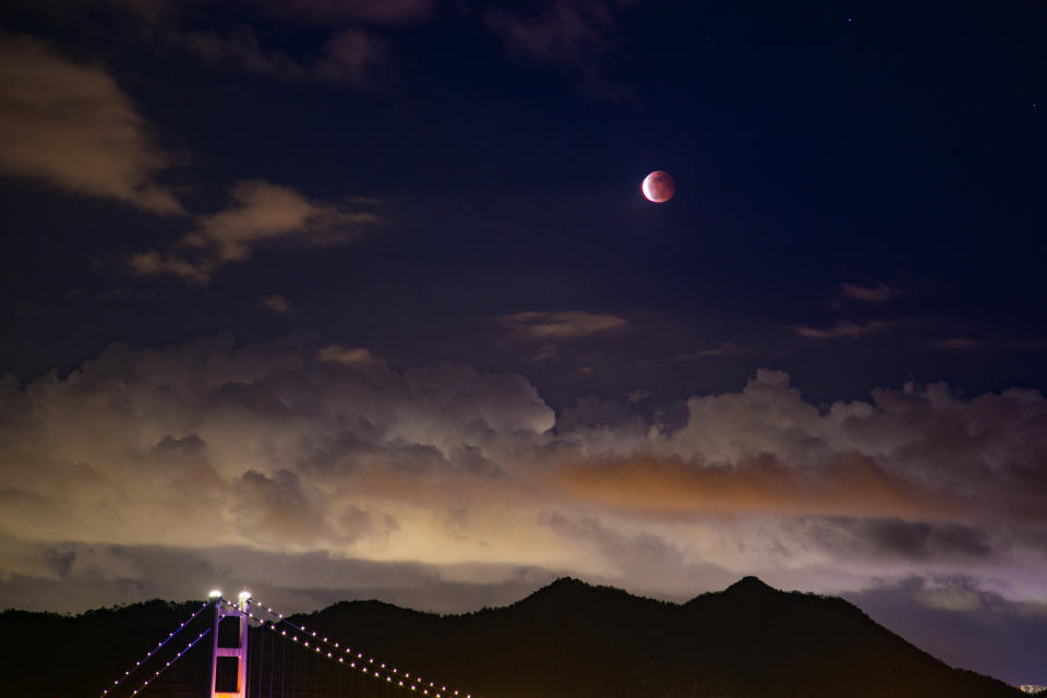 HONG KONG, CHINA - 2021/05/26: A reddish blood moon is seen above the Tsing Ma Bridge in Hong Kong.
A reddish blood supermoon eclipse appears in the night sky of Hong Kong tonight. The last super blood moon visible in Hong Kong was 21 years ago. (Photo by Dominic Chiu/SOPA Images/LightRocket via Getty Images)