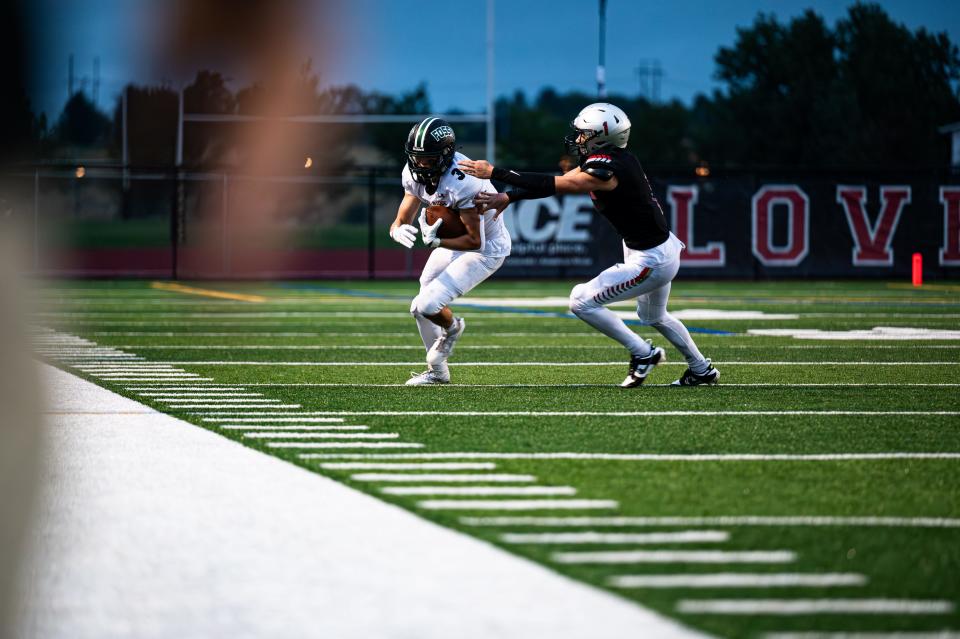 Marcus Mozer (3) of the Fossil Ridge Sabercats tries to outrun a Loveland defender during the season opener at Ray Patterson Field in Loveland on Friday, Aug. 25, 2023. Fossil Ridge lost 28-26.